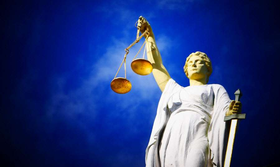 La giustizia rappresentata come una donna bendata che regge una bilancia con una mano e impugna una spada nell'altra